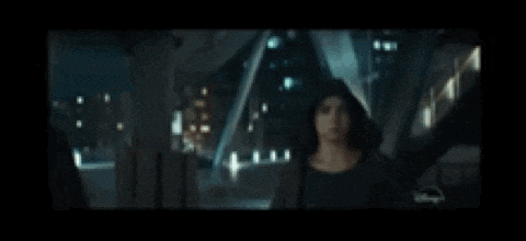 a man and a woman are walking down a dark street at night .