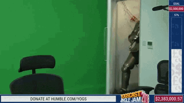 a green screen with a chair and a sign that says donate at humble.com/yogs on it