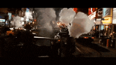 a busy city street with smoke coming out of a building that says mcdonald 's on it