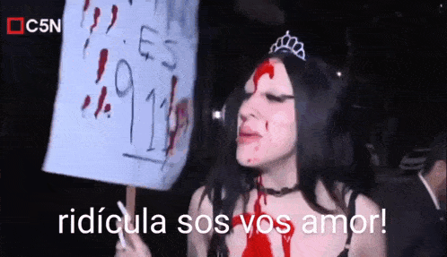 a woman with blood on her face is holding a sign that reads ridicula sos vos amor