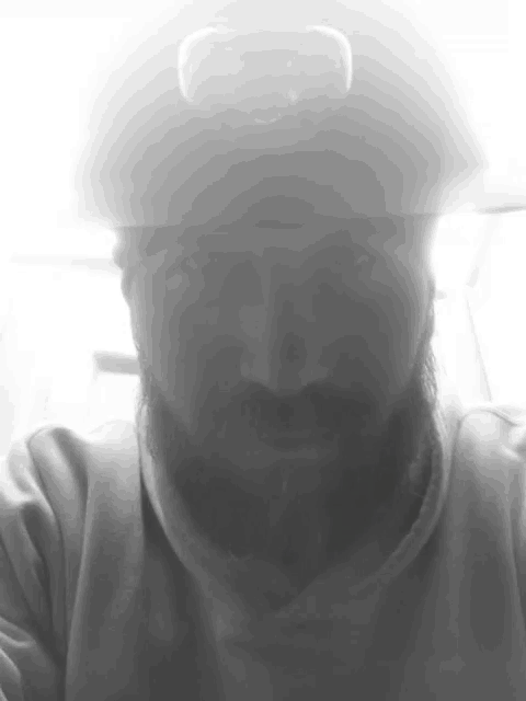 a black and white photo of a man with a beard wearing a helmet