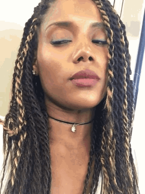 a close up of a woman 's face with her eyes closed and a choker around her neck