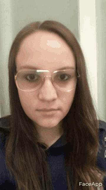 a woman wearing glasses and a blue shirt has faceapp written on the bottom