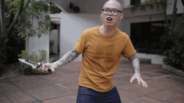 a man in a yellow shirt holds a sword in his hand