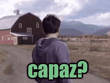 a man standing in front of a red barn with the words capaz written on the bottom