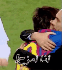 a man is hugging another man with arabic writing on the bottom