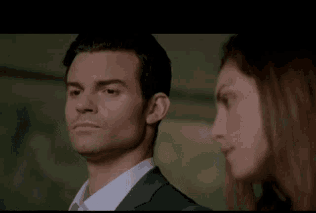 a man and a woman are standing next to each other in a room .