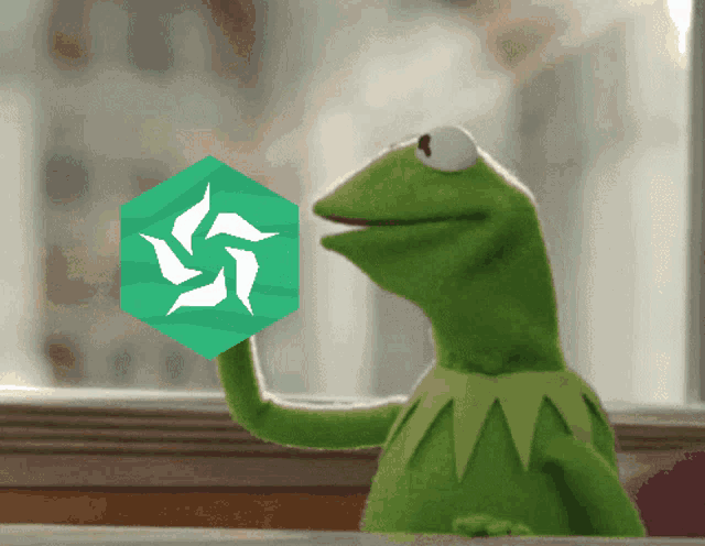 kermit the frog holding a green cube with a white swastika on it