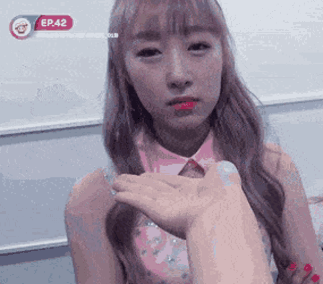a girl in a pink shirt is being held by a person with ep 42 on the bottom