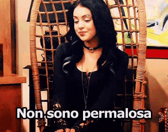 a woman is sitting in a wicker chair with the words non sono permalosa written below her
