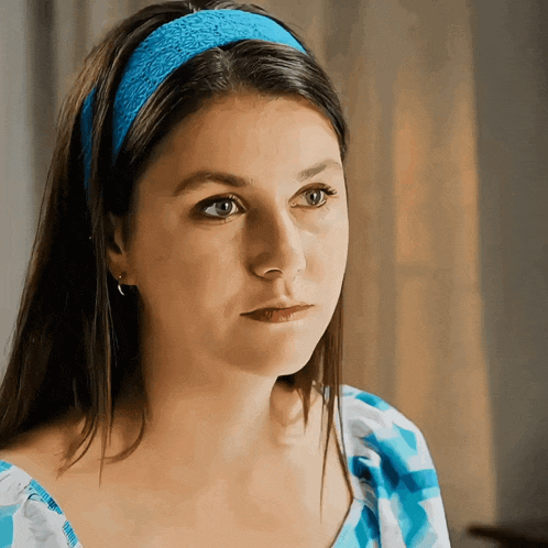 a woman wearing a blue headband and a blue and white dress