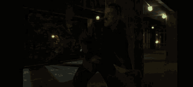 a man with a beard is holding a hammer in a dark room