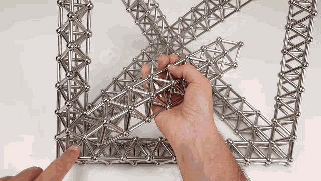 a person is playing with a metal structure that looks like a triangle