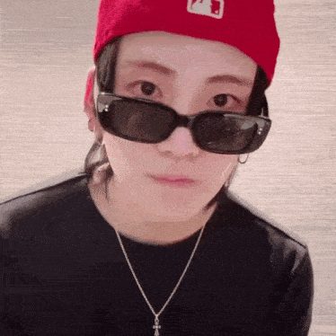a close up of a person wearing sunglasses and a red hat