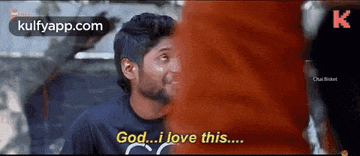 a man in a black shirt is talking to another man and says god i love this