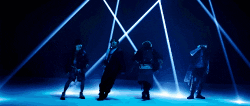 a group of people are dancing in front of a blue background