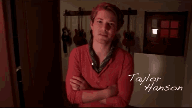 a man in a red shirt with taylor hanson written on the bottom
