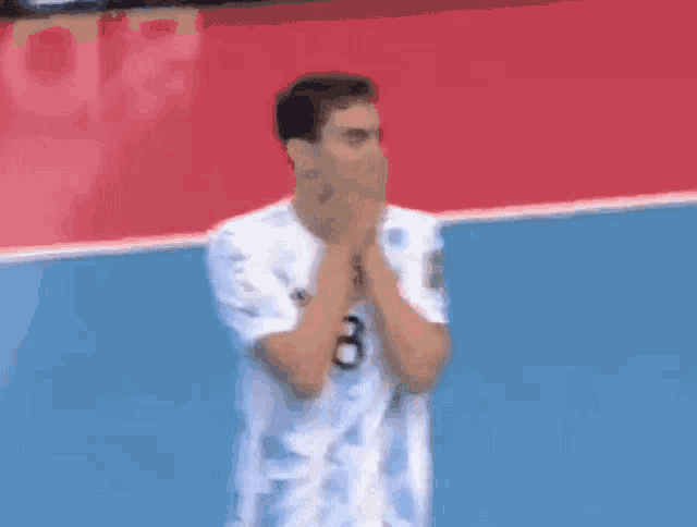 a soccer player with the number 8 on his jersey is covering his mouth with his hands