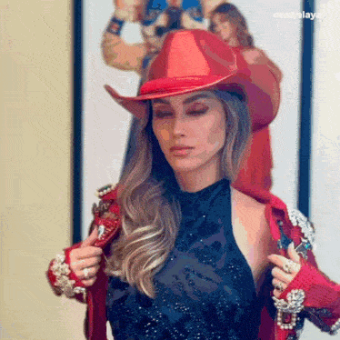 a woman wearing a cowboy hat and a red jacket