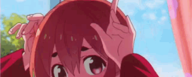 a girl is making a funny face with her hands on her head .