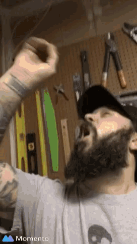 a man with a beard is wearing a hat and a shirt that says momento