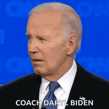 a man in a suit and tie is standing in front of a microphone and says coach daryl biden .