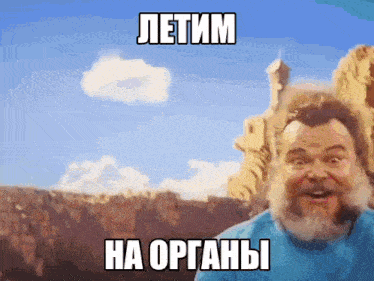 a man with a beard is standing in front of a canyon with the words " летим на органы " on his face