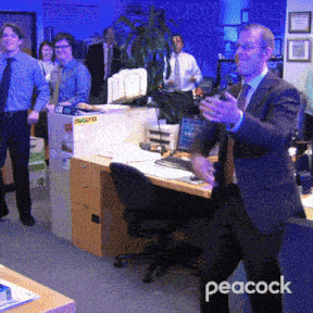 a man in a suit and tie stands in an office with peacock written on the bottom