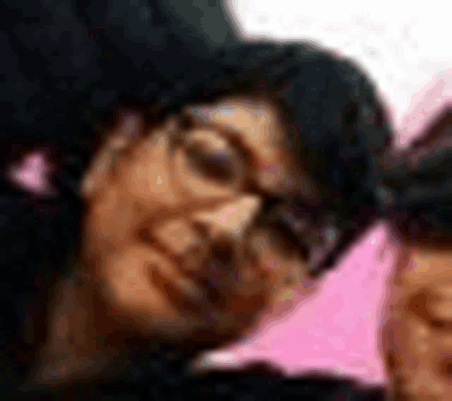 a close up of a woman 's face with glasses and a pink umbrella in the background .