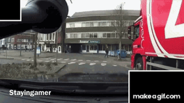 a red truck with the letter l on it is driving down a street