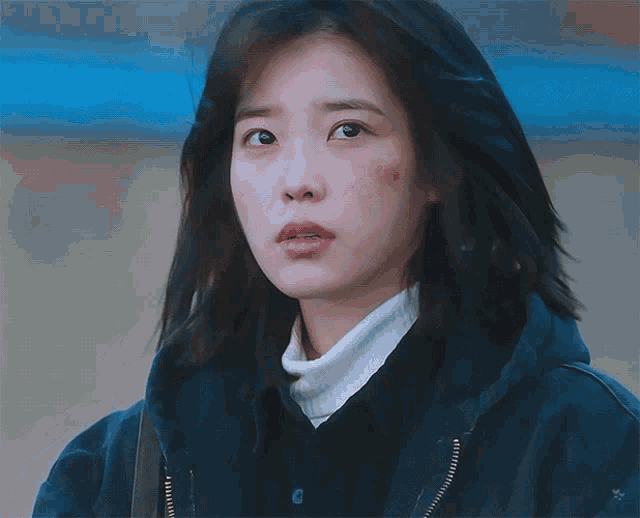 a close up of a woman 's face with korean writing on the bottom right