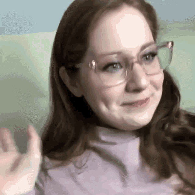 a close up of a woman wearing glasses and a turtleneck .