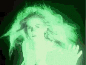 a woman with long hair is glowing in the dark with a green light coming out of her head .