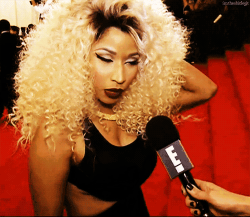 a woman with blonde curly hair is being interviewed by someone holding a microphone that has the letter f on it