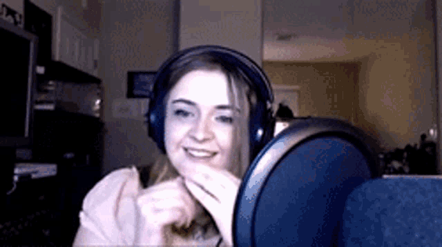 a woman wearing headphones and a microphone is smiling .