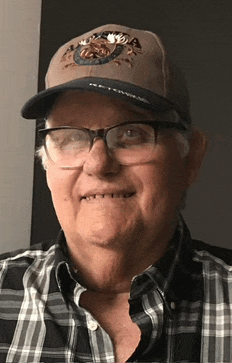 a man wearing glasses and a baseball cap with alaska on it