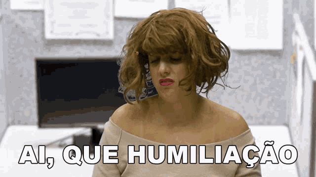 a woman wearing a wig is sitting in front of a computer and the words ai que humiliacao are below her