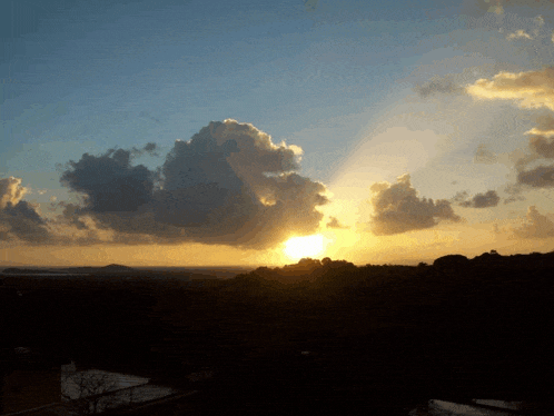 the sun shines through the clouds in the sky at sunset