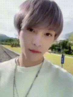 a close up of a person wearing a white shirt and a necklace