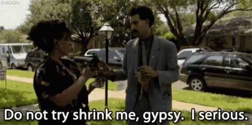 a man in a suit is talking to a woman who is holding a gun and says do not try shrink me gypsy