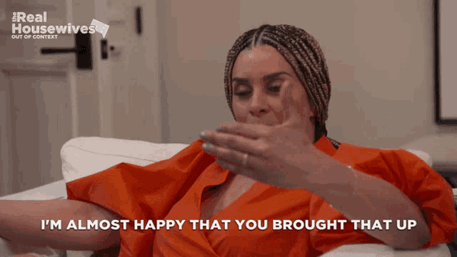 a woman sitting on a couch with the words " i 'm almost happy that you brought that up " next to her