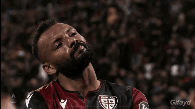 a man with a beard and sweat on his face looks up at the sky with a gifyd logo in the corner