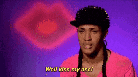 a man in a pink shirt is saying `` well kiss my ass '' in front of a pink heart .