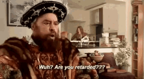 a man in a costume is sitting on a couch in a living room and talking to someone .