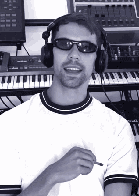 a man wearing headphones and sunglasses is standing in front of a keyboard that says special on it