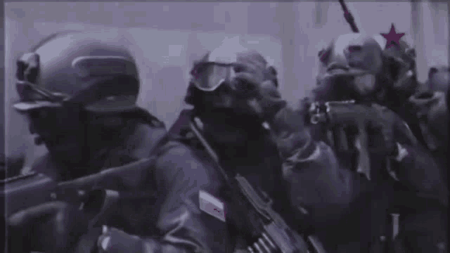 a group of soldiers are holding guns and wearing gas masks and helmets .