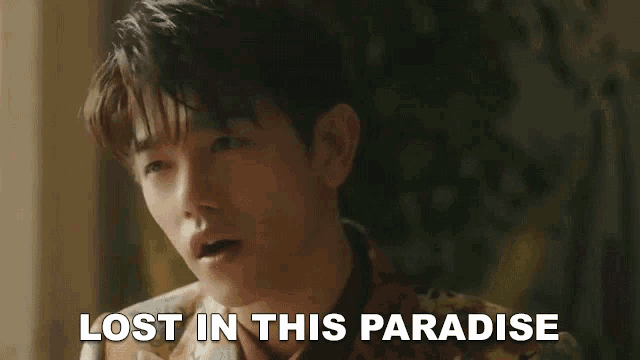 a young man is looking at the camera with the words `` lost in this paradise '' written above him .