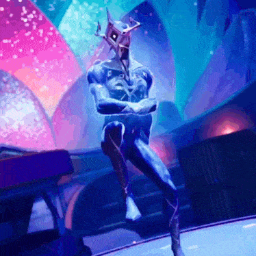 a man in a blue suit with a mask on his head is dancing on a stage