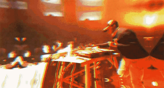a blurry image of a man playing a musical instrument in front of a crowd