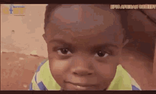 a young boy is looking at the camera with a serious look on his face .